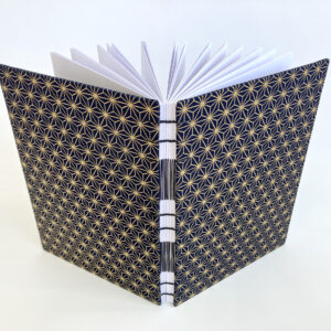 An A5 sized notebook featuring a traditional Japanese pattern called "asanoha". The book is upright and opened.