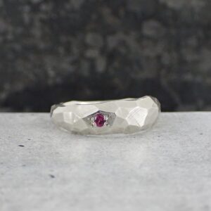 Modern silver ring set with small round ruby