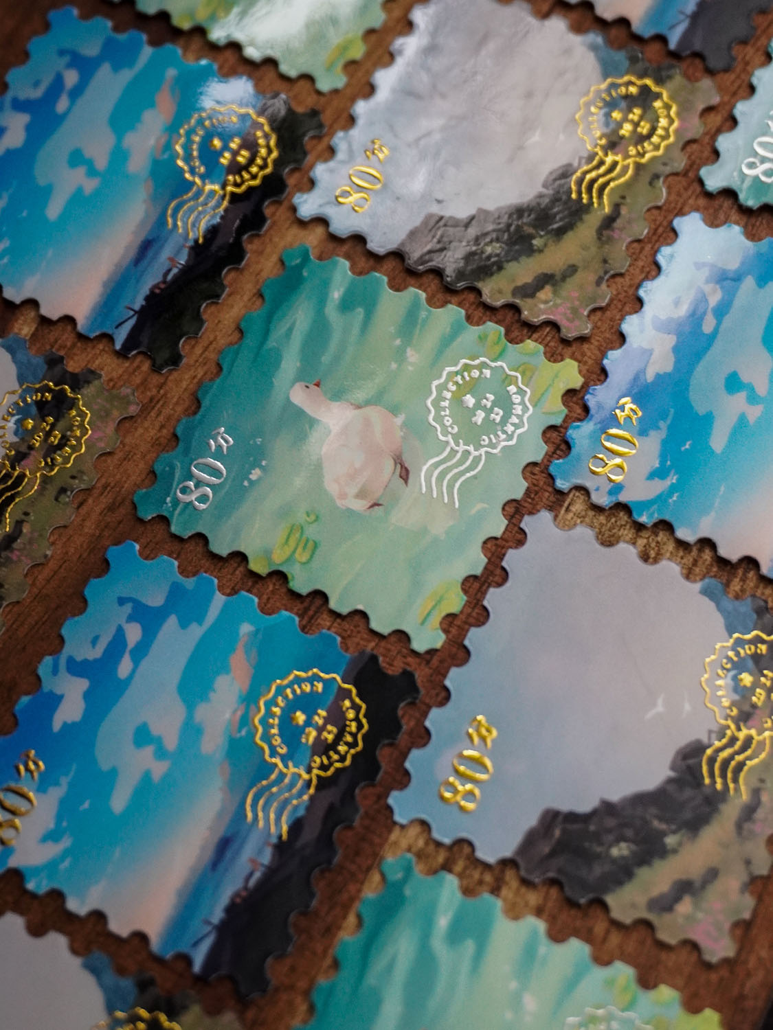 Mini Traveller: Foil stamp stickers by Vauliys Rows of stamp-like stickers with gold and silver foil elements. Designs include the ocean, a goose in the water & a grassy field