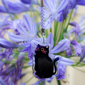 Acrylic & Epoxy phone charm of a black cat in sitting position with a purple braided cord.