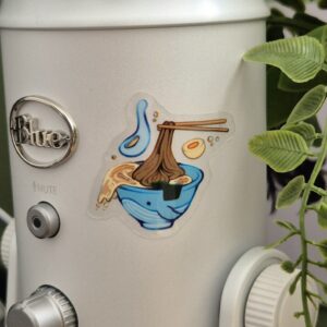 Clear sticker of a whale shaped ramen bowl stuck on a microphone.