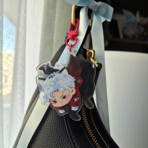 Acrylic keychain of a white haired character with cat ears and a tail dangling from a red clasp by their jacket. A crow sits on the humanoid cat's head.
