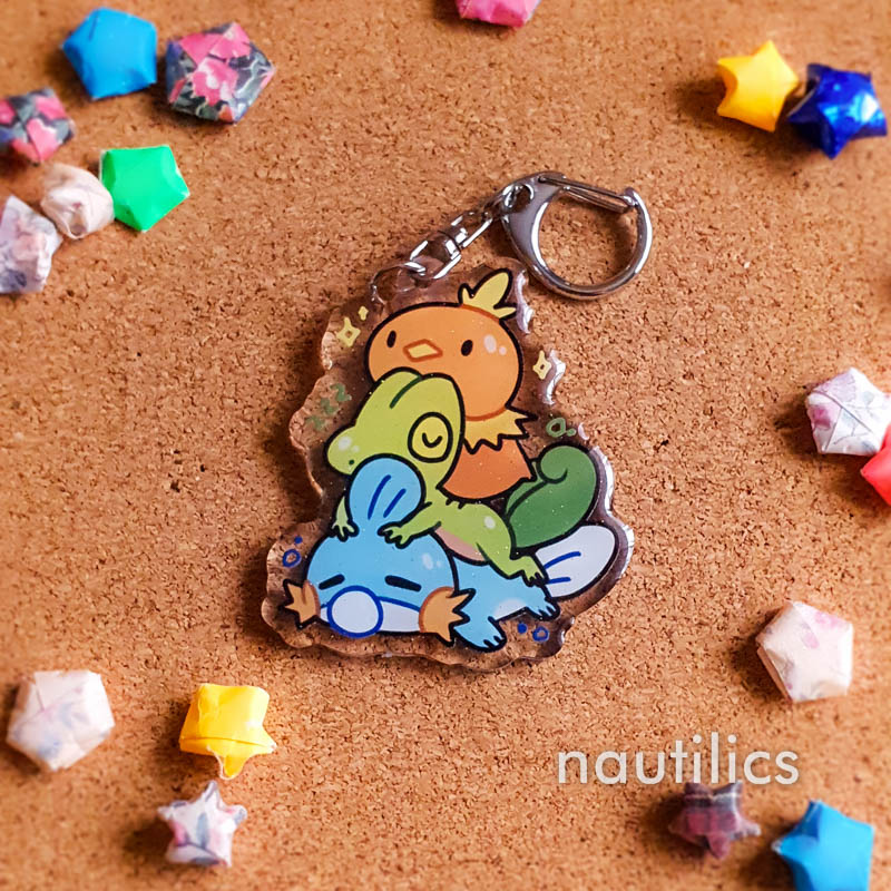 Pokemon Starters Acrylic Charms (B-Grade) by Nautilics Photo of an acrylic charm featuring the Hoenn Pokemon starters, stacked atop each other in a pile.