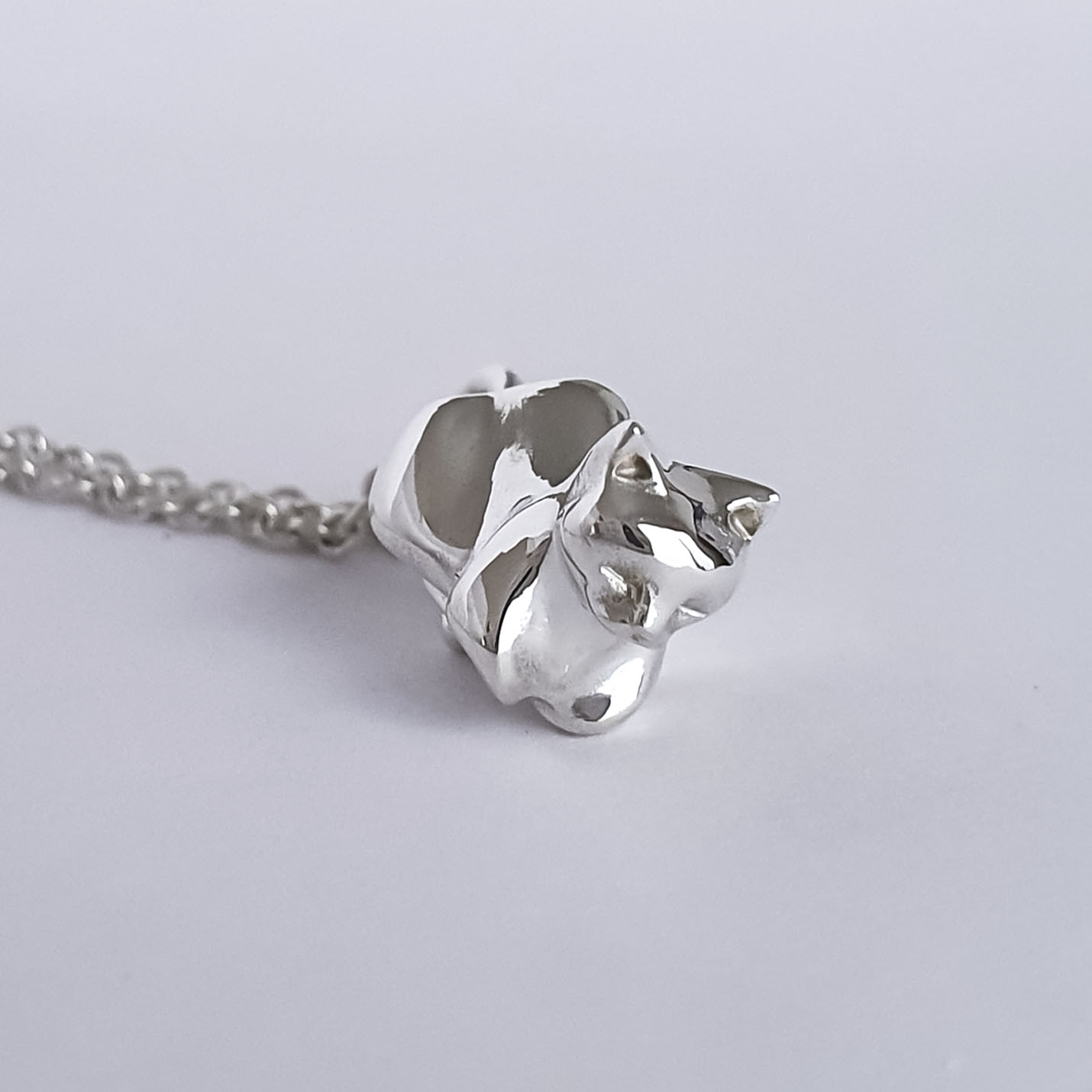 CAT LOAF STERLING SILVER PENDANT by LarNau Treasures Sterling Silver Cat hanging from a chain, that's tucked in a cat loaf.