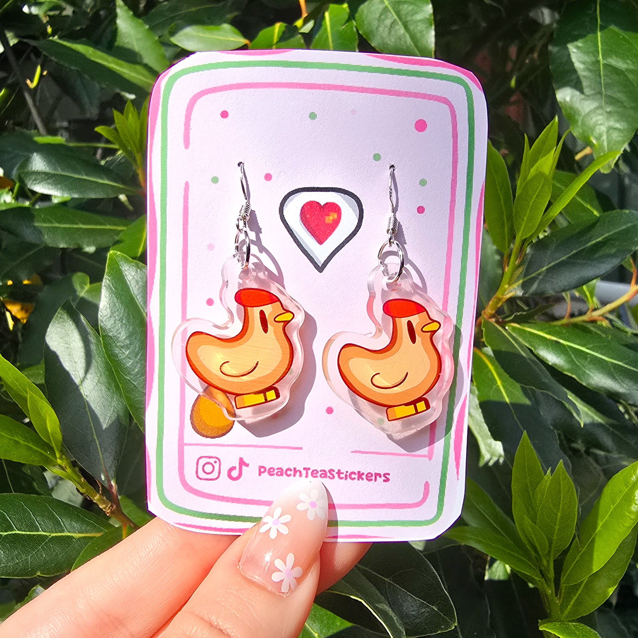 Stardew Valley Chicken Dangle Earrings by PeachTeaStickers Add a touch of Stardew Valley charm to your everyday look with these adorable chicken earrings! 🐔 Perfect for gamers and animal lovers alike, each earring features a lightweight dangle design measuring approximately 2.5 cm in length, making them comfortable for all-day wear. Crafted with care, these earrings are ideal for casual outfits, gaming events, or gifting to fellow Stardew Valley fans.