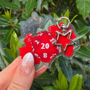 Bring a touch of charm, danger, and vampire flair to your everyday life with this Astarion-inspired D20 acrylic keyring! Featuring a double-sided design and a standard chain, this shiny acrylic charm captures the elegance and mischief of everyone’s favourite rogue.