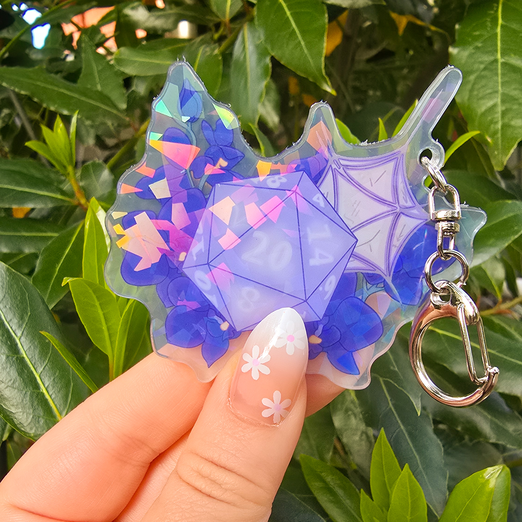 Baldur's Gate 3 Holo Shadowheart DND Die Inspired Keyring by PeachTeaStickers Carry a touch of mystery and devotion with this Shadowheart-inspired D20 acrylic keyring. Featuring a double-sided design and a standard metal chain, this beautiful accessory is perfect for fans who want to keep a little bit of the Night Orchid cleric with them wherever they go.